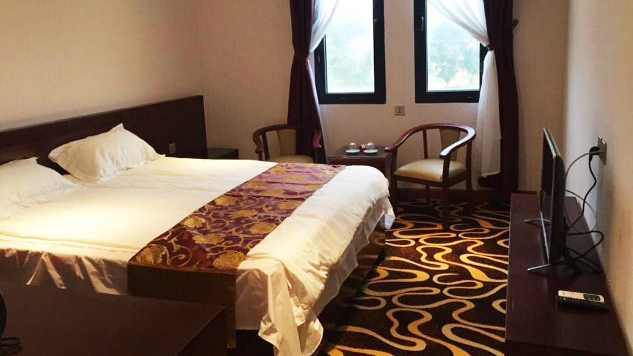 Phòng khách sạn Hoàng Trung Cô Tô được trải thảm nâu vàng, nội thất gỗ mang đến không gian ấm áp. Nguồn: Internet